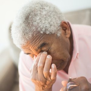 elderly man in pink shirt closing his eyes