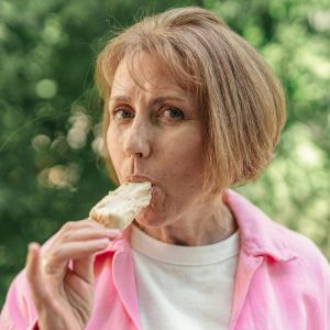 an elderly woman eating an ice cream