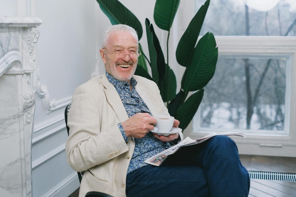 smiling elderly man while drinking tea