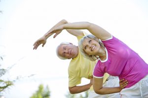 Active senior couple doing side bends